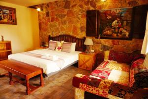een slaapkamer met een bed en een bank bij Swiss Hotel Pattaya in Sattahip