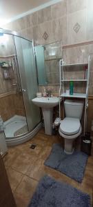 y baño con ducha, aseo y lavamanos. en Villa, en Bishkek