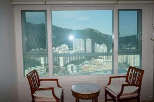 two chairs and a table in front of a window at Umi House in Busan