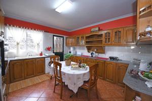 eine Küche mit einem Tisch mit Stühlen und einem Waschbecken in der Unterkunft 3 bedrooms house with terrace and wifi at Ponta do Sol in Ponta do Sol