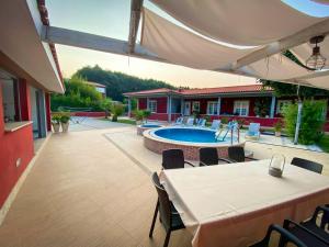 un patio con mesa y sillas y una piscina en 4 bedrooms villa with private pool jacuzzi and terrace at Rebordoes Souto, en Rebordões