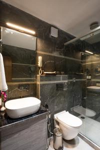 a bathroom with a sink and a toilet and a shower at Regenta Place Raaj Agra in Agra