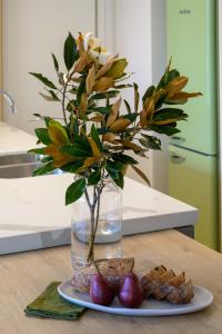 a vase filled with flowers and a plate of food at Brisbane Luxury Gabba Apartment in Brisbane