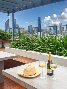 布里斯本的住宿－Brisbane Luxury Gabba Apartment，一张桌子,上面放着一瓶葡萄酒和两杯酒