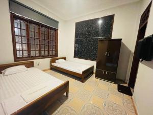 a small room with two beds and a tv at CHUNG BẰNG MOTEL in Hương Hóa