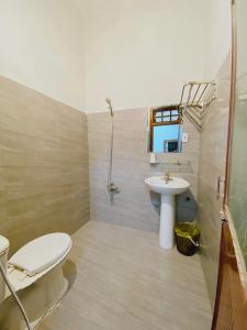 a bathroom with a white toilet and a sink at CHUNG BẰNG MOTEL in Hương Hóa