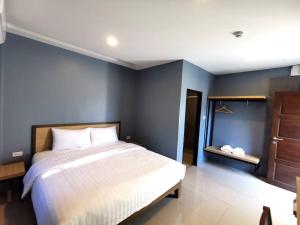 Un dormitorio con una cama y una pared azul. en No89BoutiqueHotel, en Ban Khao Din