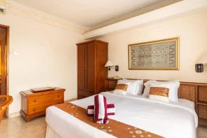 a bedroom with a large white bed and a wooden cabinet at Jayakarta Residence - Sandy Sunset Suite 1BR - 6432 in Seminyak +22 photos