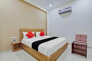 een slaapkamer met een bed en een stoel erin bij Super Collection O Hotel Roxas in Jaipur