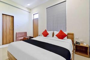 een hotelkamer met een groot bed en een stoel bij Super Collection O Hotel Roxas in Jaipur