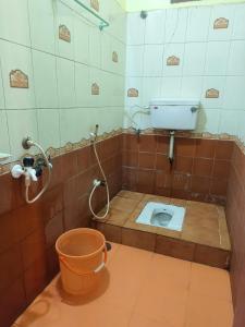 a bathroom with a toilet with a bucket in it at Sri Kanya Residency, Srikalahasti in Srikalahasti