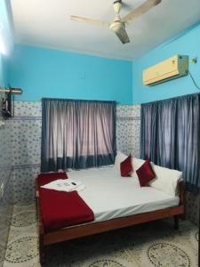 a bedroom with a bed with a ceiling fan at Sri Kanya Residency, Srikalahasti in Srikalahasti