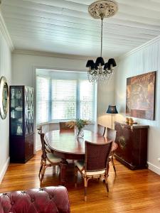 a dining room with a table and chairs and a chandelier at Charming heritage house in the heart of the city in Brisbane