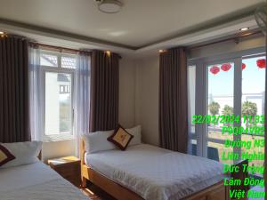 1 dormitorio con 2 camas y ventana en Khách sạn Hoàng Hảo, en Ðưc Trọng