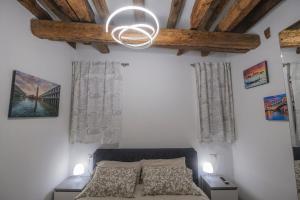 a bedroom with a bed and a chandelier at Ca' Spritz - Home in Venice