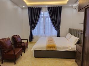 a bedroom with a bed and a chair and a window at 4L HOTEL KIM BÔI in Làng Trang