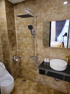W łazience znajduje się umywalka, toaleta i lustro. w obiekcie 4L HOTEL KIM BÔI w mieście Làng Trang