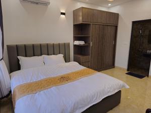 sypialnia z dużym łóżkiem i drewnianą szafką w obiekcie 4L HOTEL KIM BÔI w mieście Làng Trang
