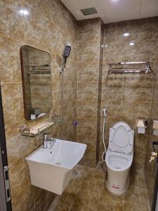 W łazience znajduje się umywalka, toaleta i lustro. w obiekcie 4L HOTEL KIM BÔI w mieście Làng Trang