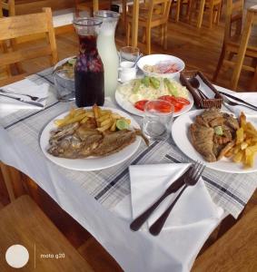 a table with two plates of food and french fries at PUNTA VELEROS ROOFTOP in Los Órganos