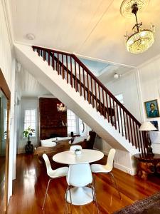a dining room with a table and a staircase at Charming heritage house in the heart of the city in Brisbane