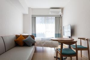 una camera d'albergo con letto, tavolo e sedie di yksi STAY ＆ APARTMENT OSAKA ad Osaka