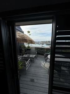 een patio met stoelen en uitzicht op het water bij Napier Apartment Ahuriri in Napier