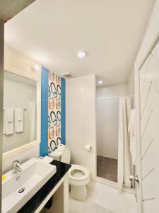 La salle de bains est pourvue de toilettes blanches et d'un lavabo. dans l'établissement PJ Guest House, à Chiang Rai