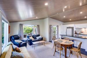 a living room with a couch and a table at Garden Retreat - Napier Holiday Home in Napier