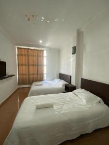 - 2 lits dans une chambre d'hôtel avec fenêtre dans l'établissement UMMUL MOTEL CMART, à Arau