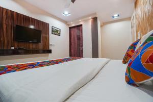 um quarto com uma cama e uma televisão de ecrã plano em FabHotel Olive Stay Inn em Nagpur