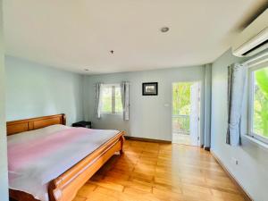 una camera con letto e pavimento in legno di PJ Guest House a Chiang Rai