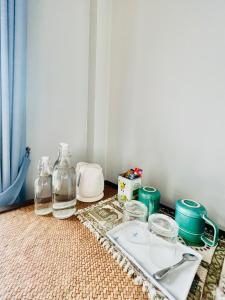 a table with a tray of dishes and glass jars at PJ Guest House in Chiang Rai