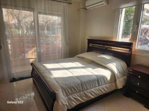 1 dormitorio con cama y ventana con vistas en George's Apartment en Volos