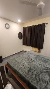 una camera con un letto e un orologio a muro di Home sweet home 3BHK a Mumbai