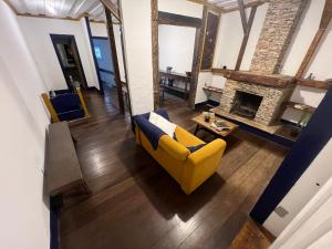a living room with a yellow couch and a fireplace at History Hostel in Ouro Preto