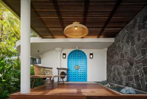 a porch with a blue door and a bench at Hard Rock Hotel Penang in Batu Ferringhi