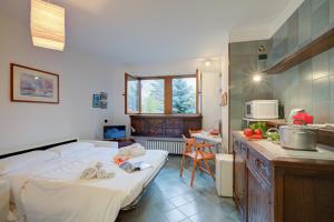 a room with two beds and a kitchen with a counter at Fiori di Miele - Happy Rentals in Bardonecchia