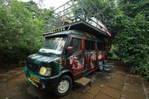a green and red van with a balcony on top at Holistic Stay Eco-Resort & Ayurvedic Retreat in Paithalmala