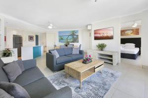 a living room with a couch and a table at Bright 2-Bed with Pool, Spa & Tennis Court in Gold Coast