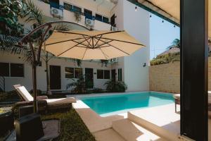 a large umbrella sitting next to a swimming pool at Guitarra Inn in Puerto Escondido