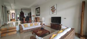 uma sala de estar com dois sofás e uma televisão em Grand Baie Villa des amis sur la plage. em Grand Baie