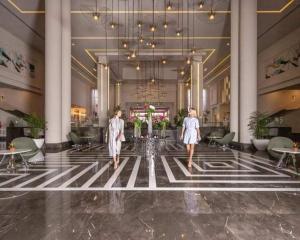 two women walking through a lobby of a hotel at Hawaii hotels & blend club resort&sea jul& in Hurghada