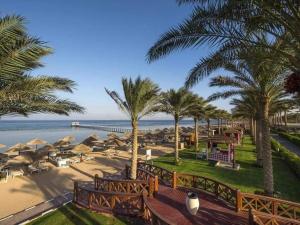 a view of a beach with palm trees and umbrellas at Hawaii hotels & blend club resort&sea jul& in Hurghada