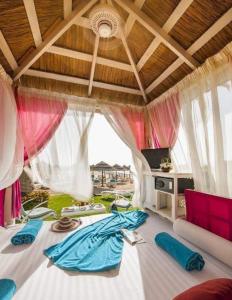 a living room with a large bed with curtains at Hawaii hotels & blend club resort&sea jul& in Hurghada