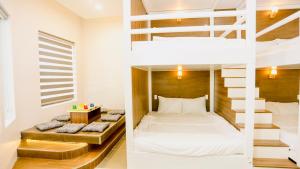 a bedroom with a bunk bed and a staircase at Kiwi's Homestay & Cafe in Ấp Khánh Phước (1)
