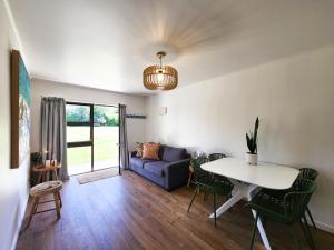 a living room with a table and a couch at Cosy Hahei Retreat in Hahei