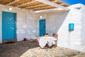 a table with two chairs and a blue door at AXONI WINDMILL HOUSE in Óthos