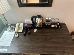 a desk with a phone and a coffee maker on it at KINGSMAN BOUTIQUE HOTEL in Kota Kinabalu