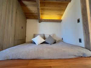uma cama num quarto com tecto em madeira em Nonpura　VACATION VILLA　iriomote em Iriomote